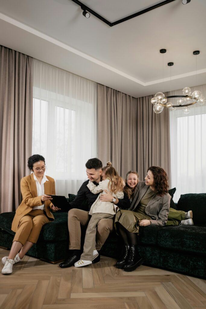 A joyful family consults with a real estate agent in their modern living room.
